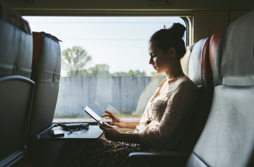 kvinna med läsplatta på tåg