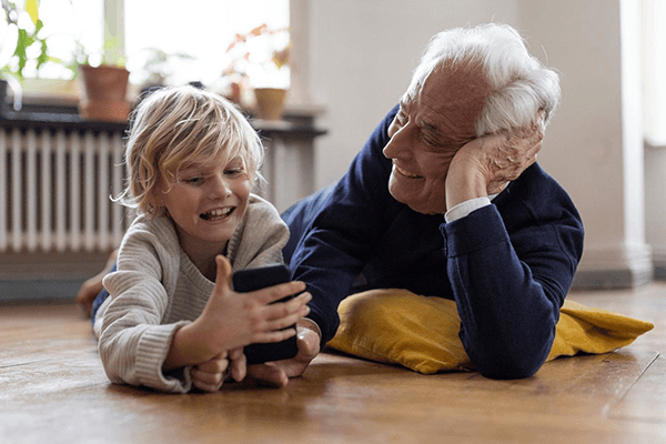 Pojke och morfar med mobiltelefon.