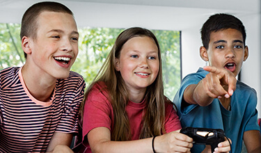 Tre ungdomar spelar tv-spel.