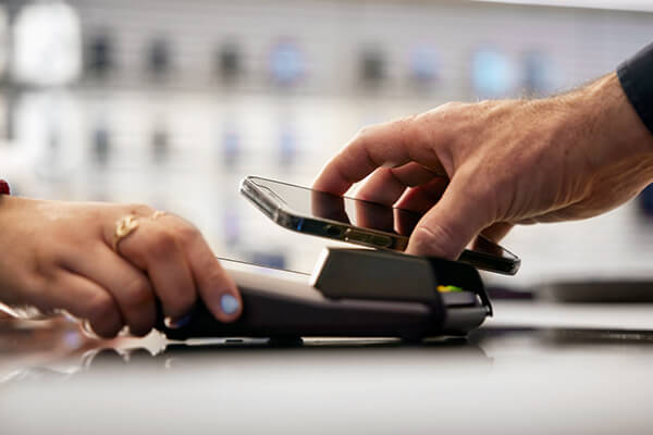 Person gör digitalt köp genom att blippa mobilen.