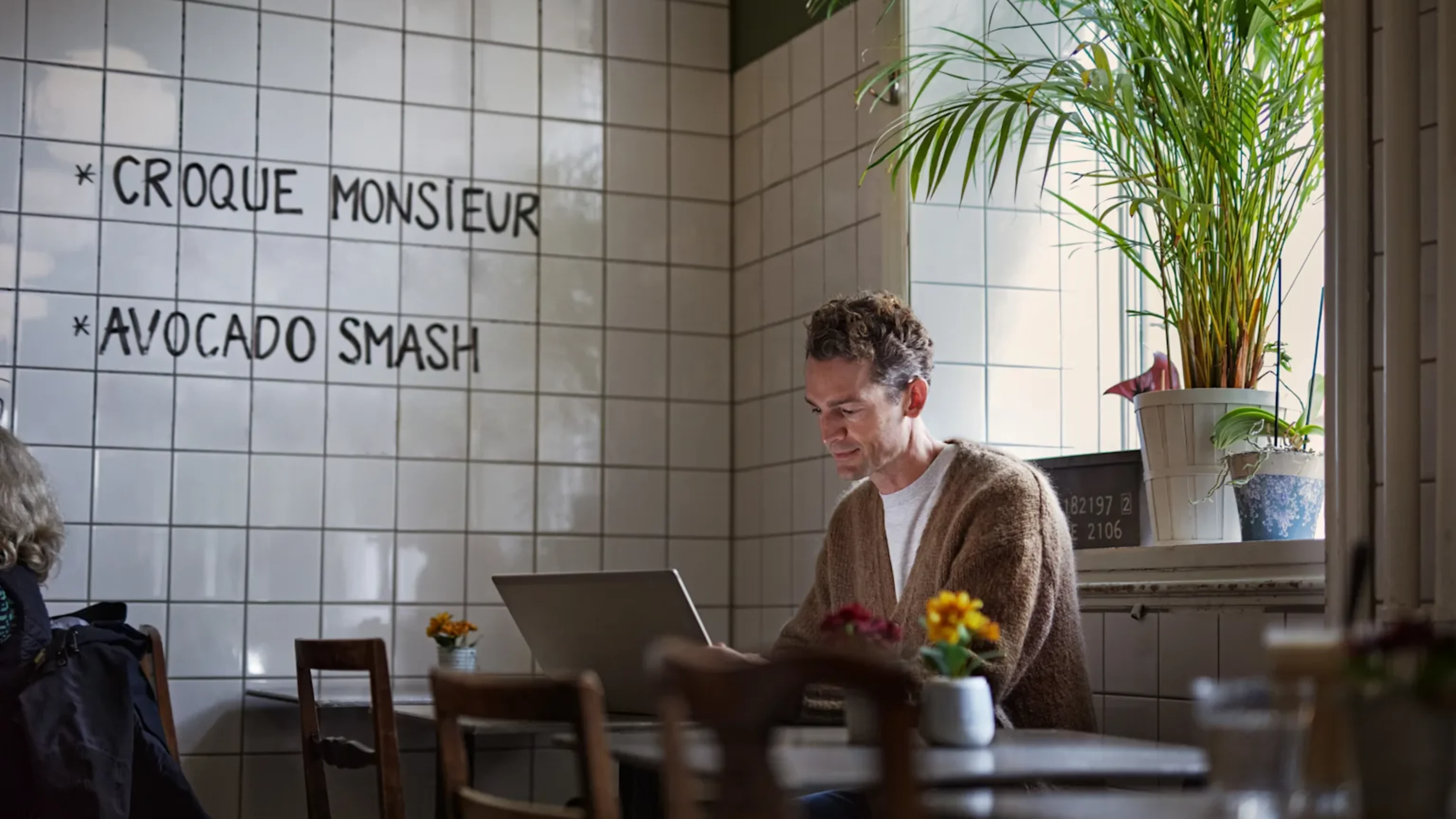 Man framför laptop på café