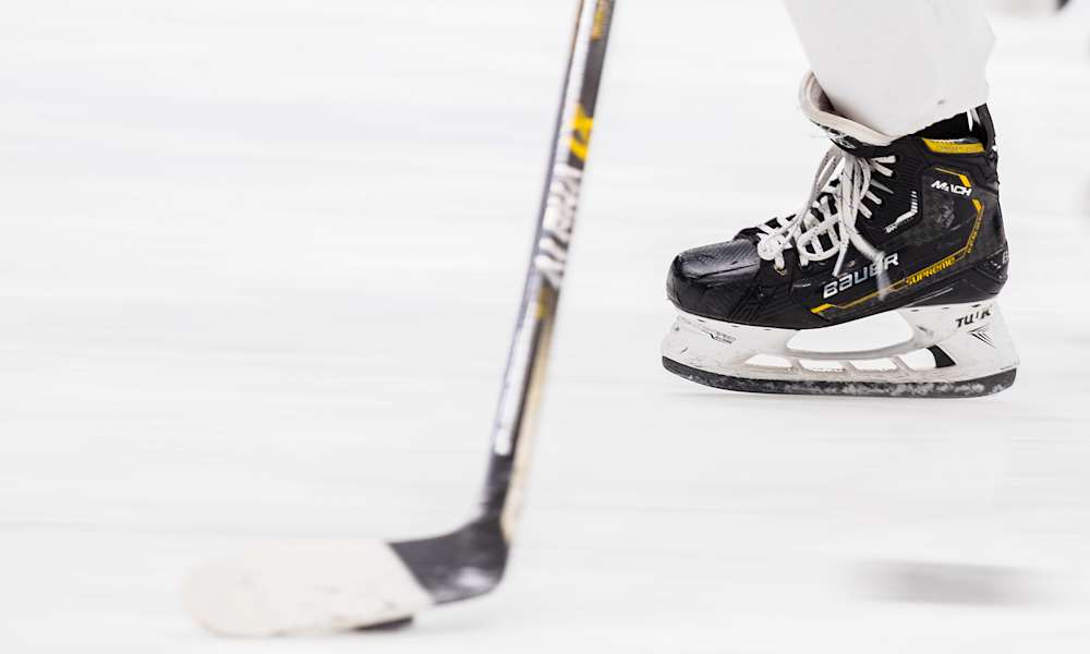 Hockeyrör och hockeyklubba på isen.