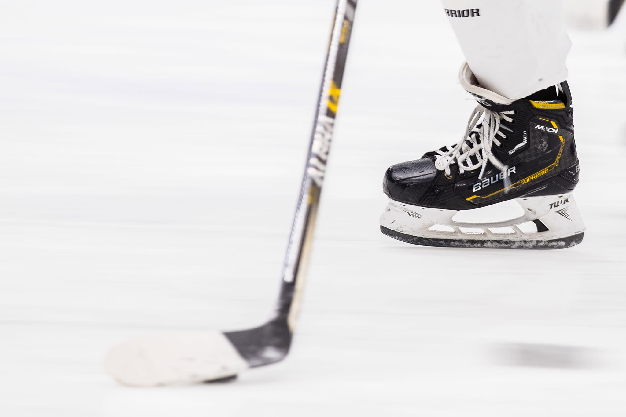 Hockeyrör och hockeyklubba på isen. 