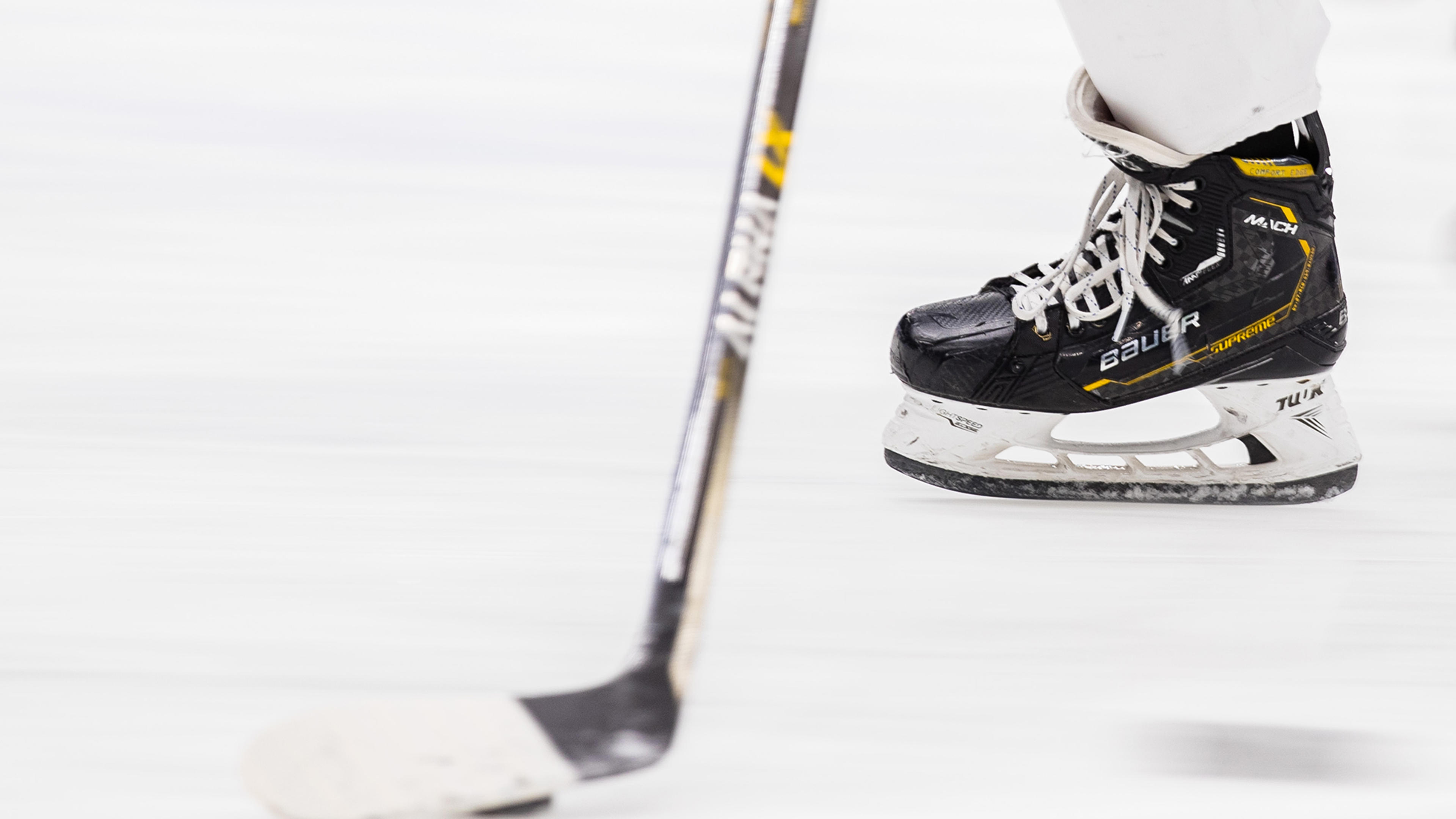 Hockeyrör och hockeyklubba på isen.