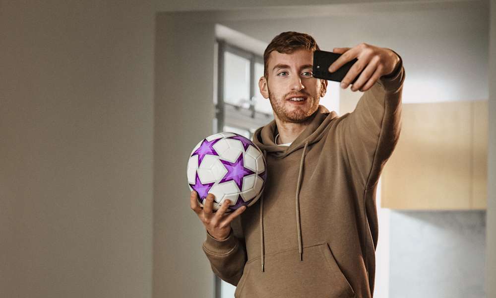 Dejan Kulusevski tar en selfie poserande med en fotboll. Kulusevski följer UEFA Champions League 2023 och alla andra ligor i Telia Play.