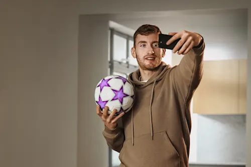 Dejan Kulusevski tar en selfie poserande med en fotboll. Kulusevski följer UEFA Champions League 2023 och alla andra ligor i Telia Play. 