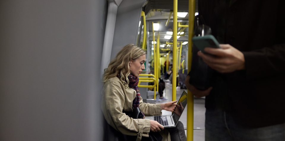 Kvinna arbetar med mobilt bredband på tunnelbanan.