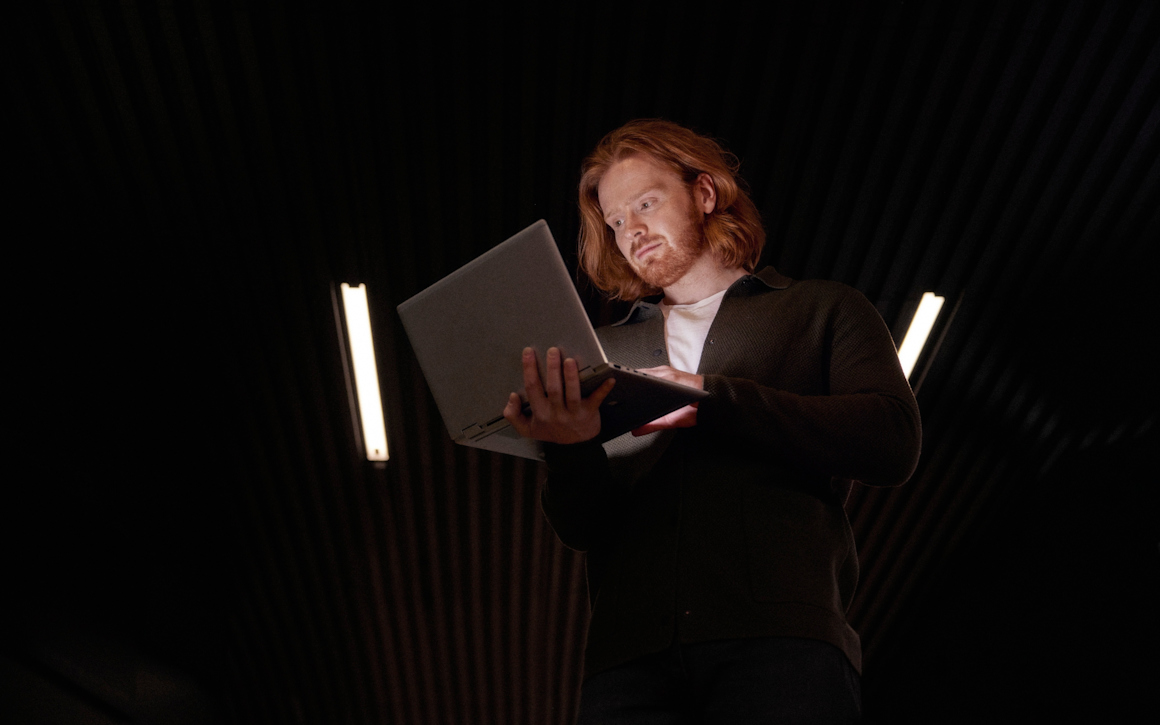 Man med rött hår och skägg som tittar på en dator