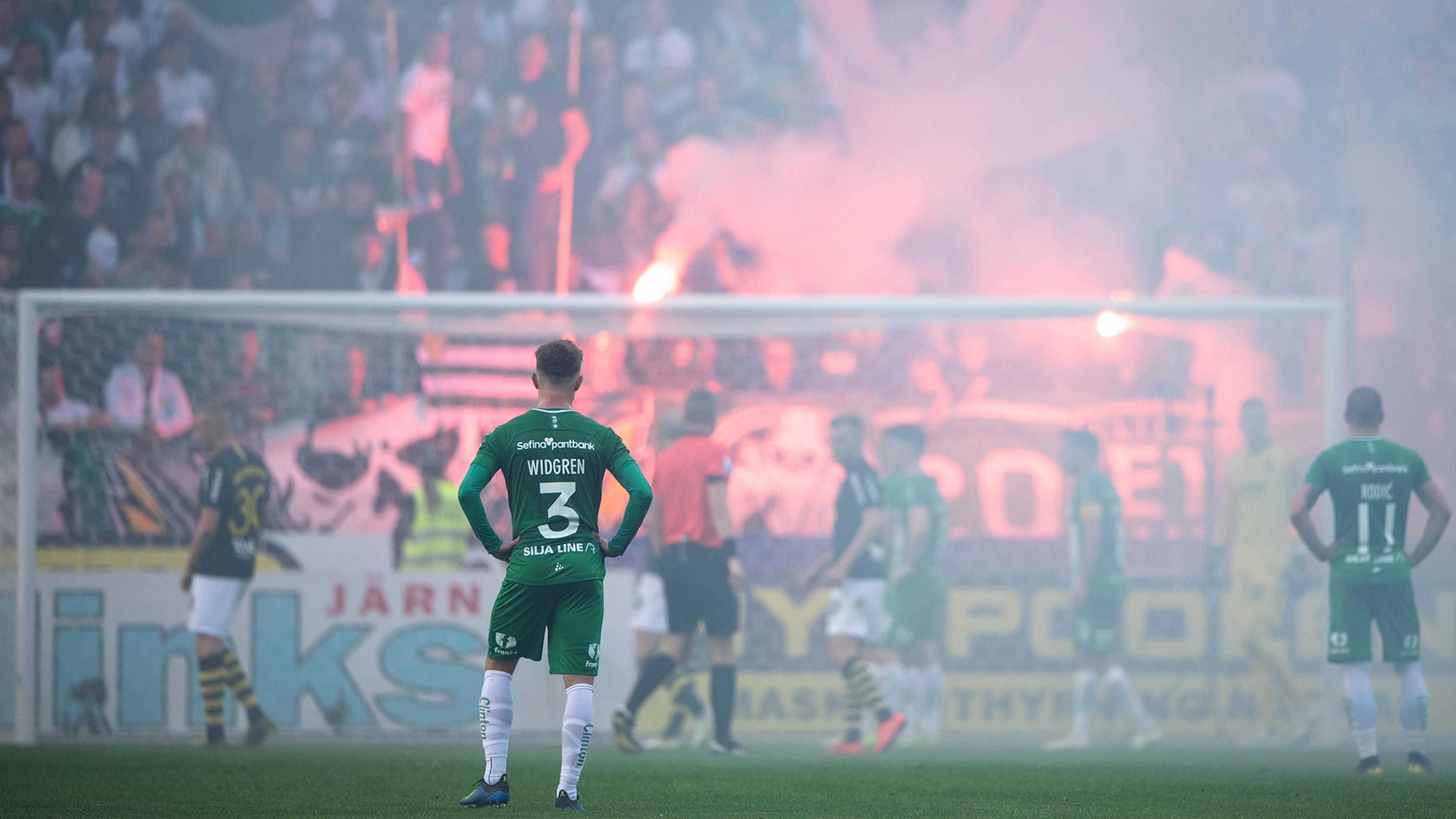 Hammarbyspelare i förgrunden under ett spelavbrott 2019 på grund av bengaliska eldar.