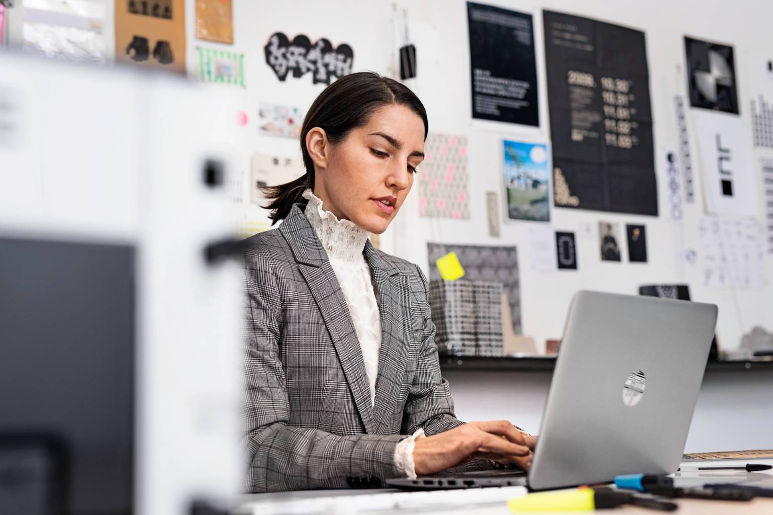 Kvinna arbetar med Smart Säkerhet på laptop på kontor.