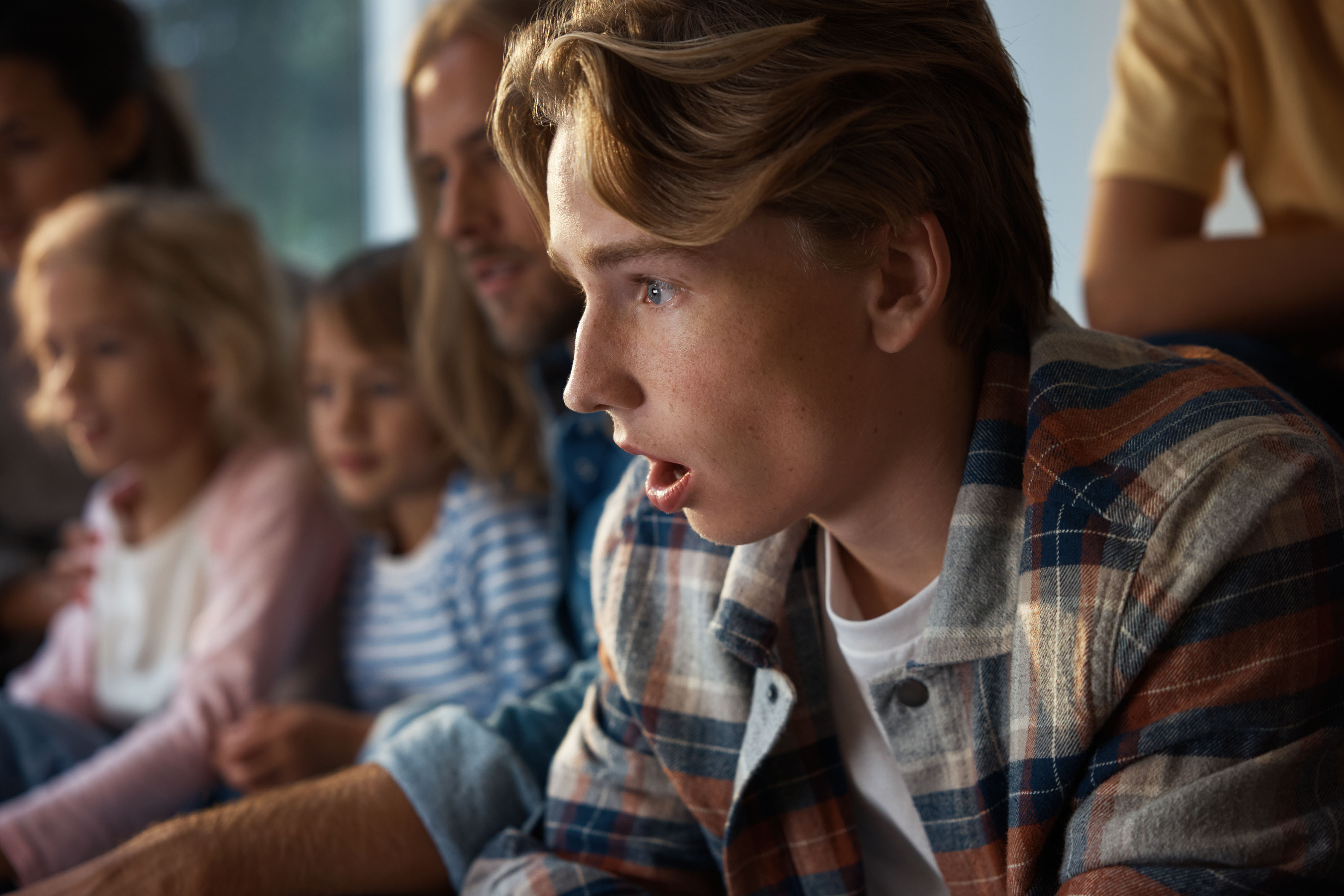 Familj tittar på tv. Kanske är det favoritlaget som gör mål? 