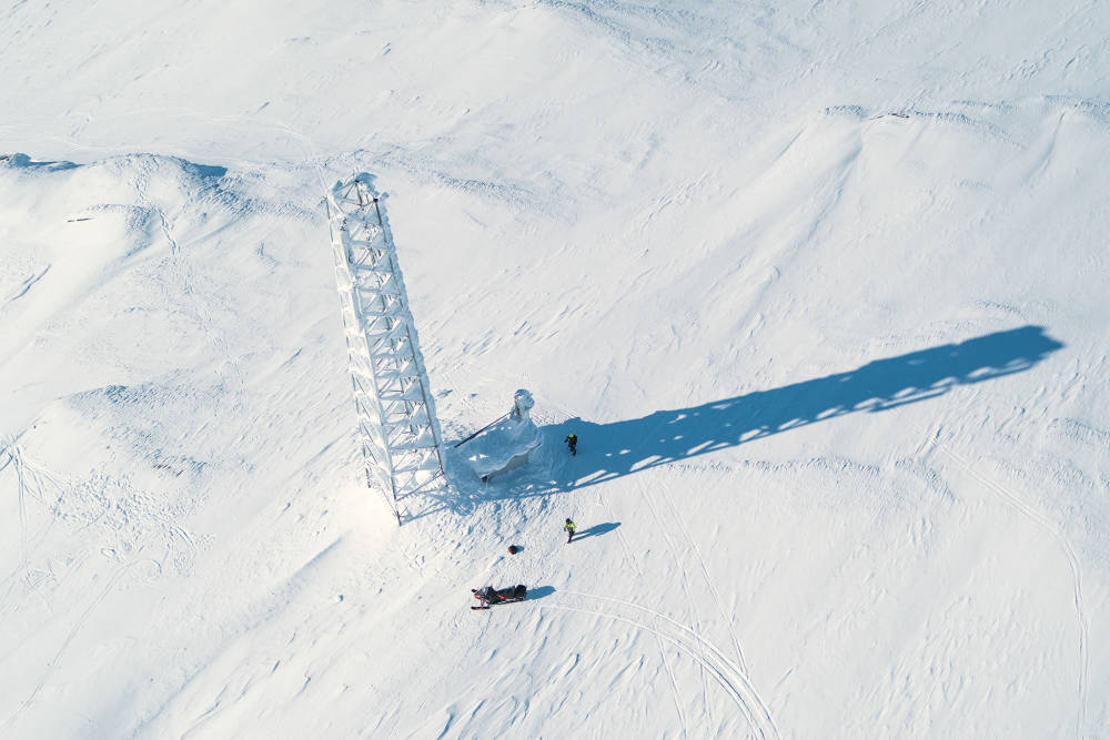 5G - mast i vinterlandskap flygbild - helikoptervy - med några arbetare i snön - Telia_Company_2023_39