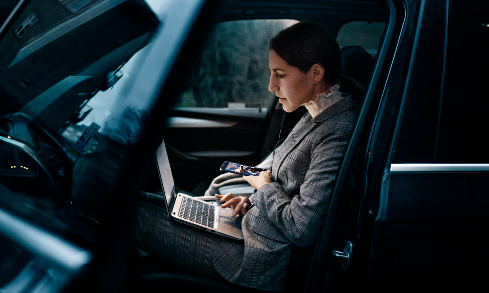Kvinna med laptop i bil