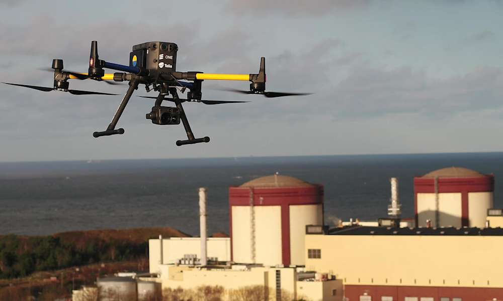 Drönare med kamera flyger över kärnkraftverk.