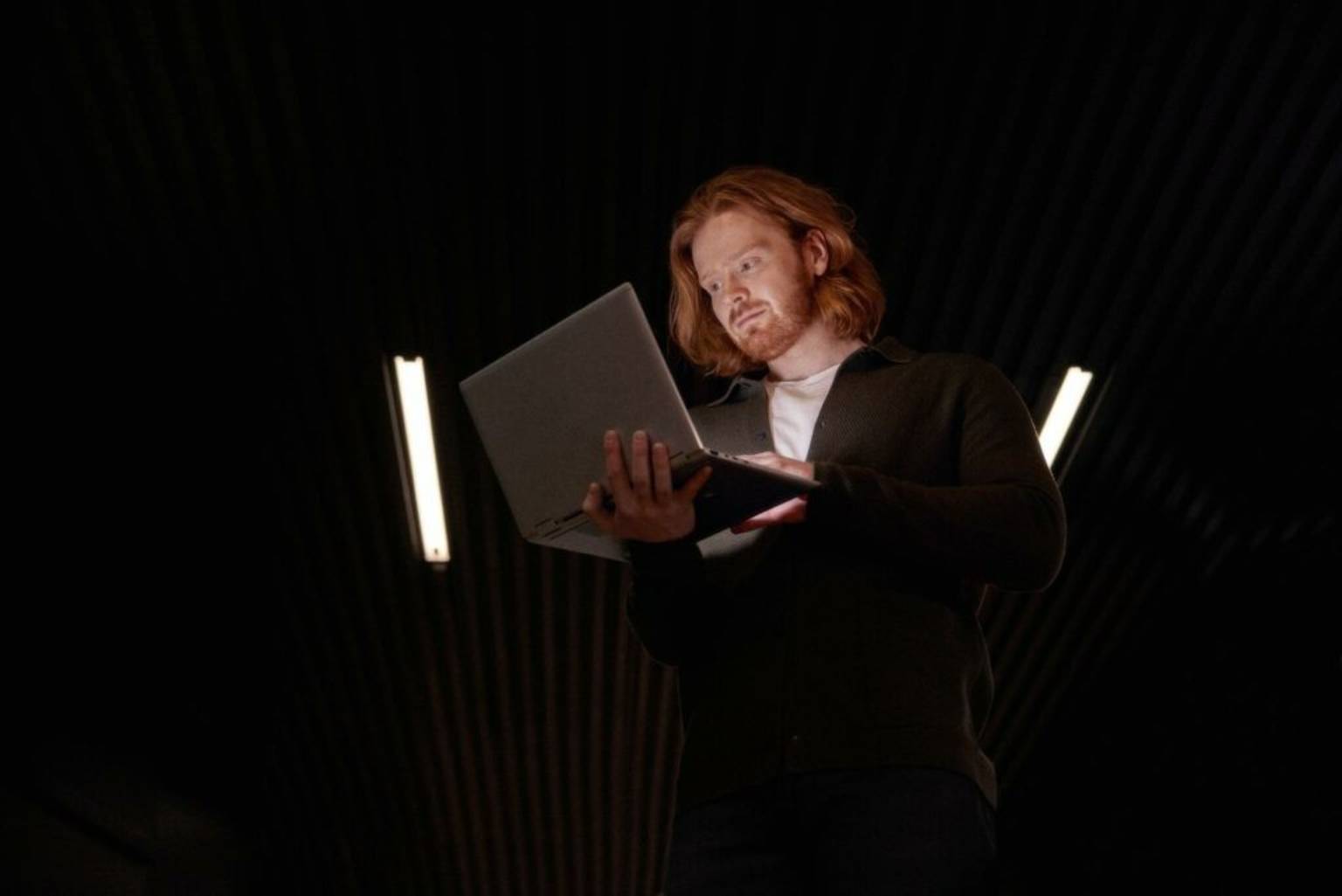 Man med rött hår och skägg som tittar på en dator