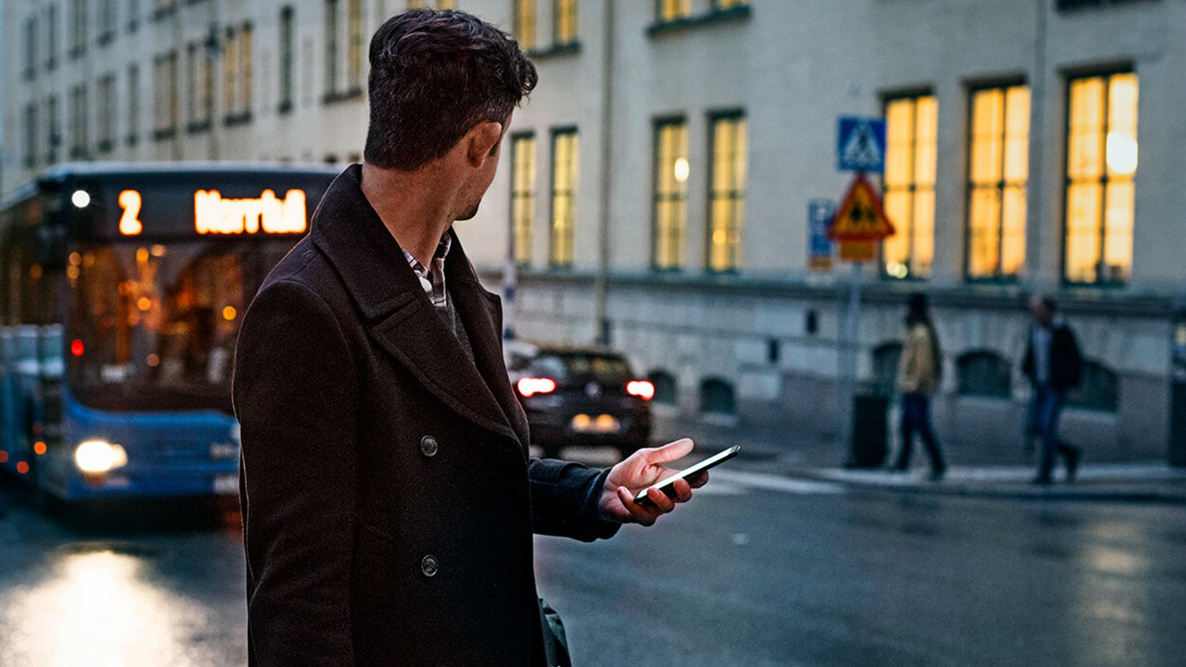 Man med mobil i en rulltrappa.