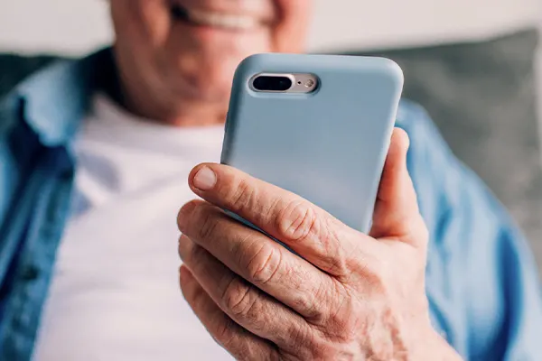 Närbild på hand med mobiltelefon.