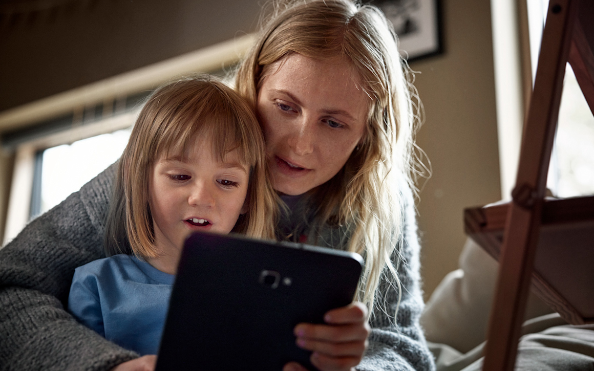 Familjemys - mamma och flicka streamar barnprogram på surfplatta.