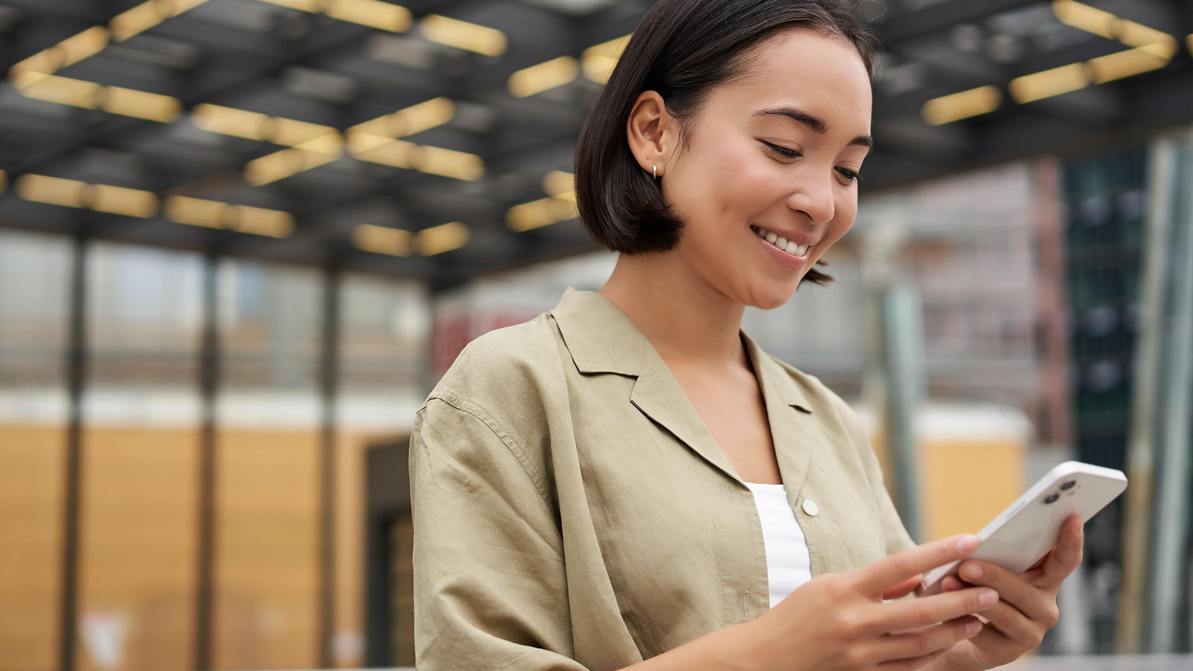 Ung leende kvinna med Telia Jobbmobil på kontor