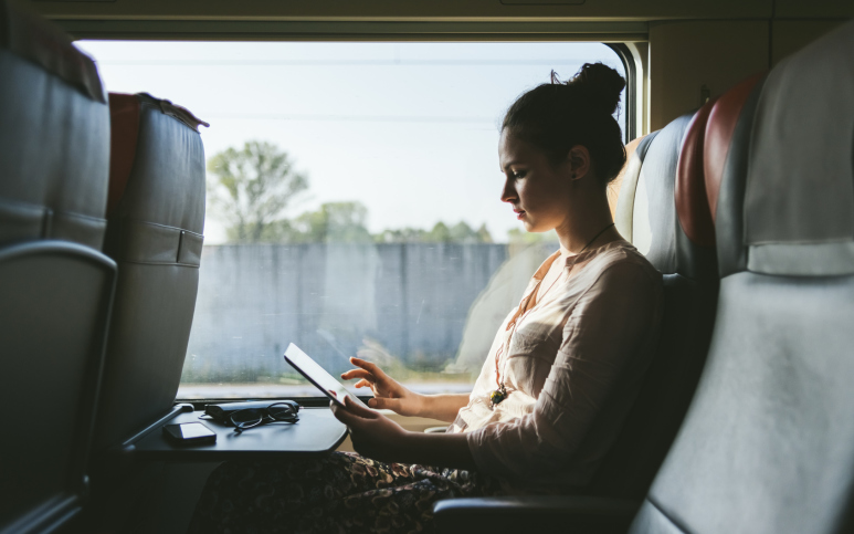 Kvinna arbetar med mobilt bredband på tåg.