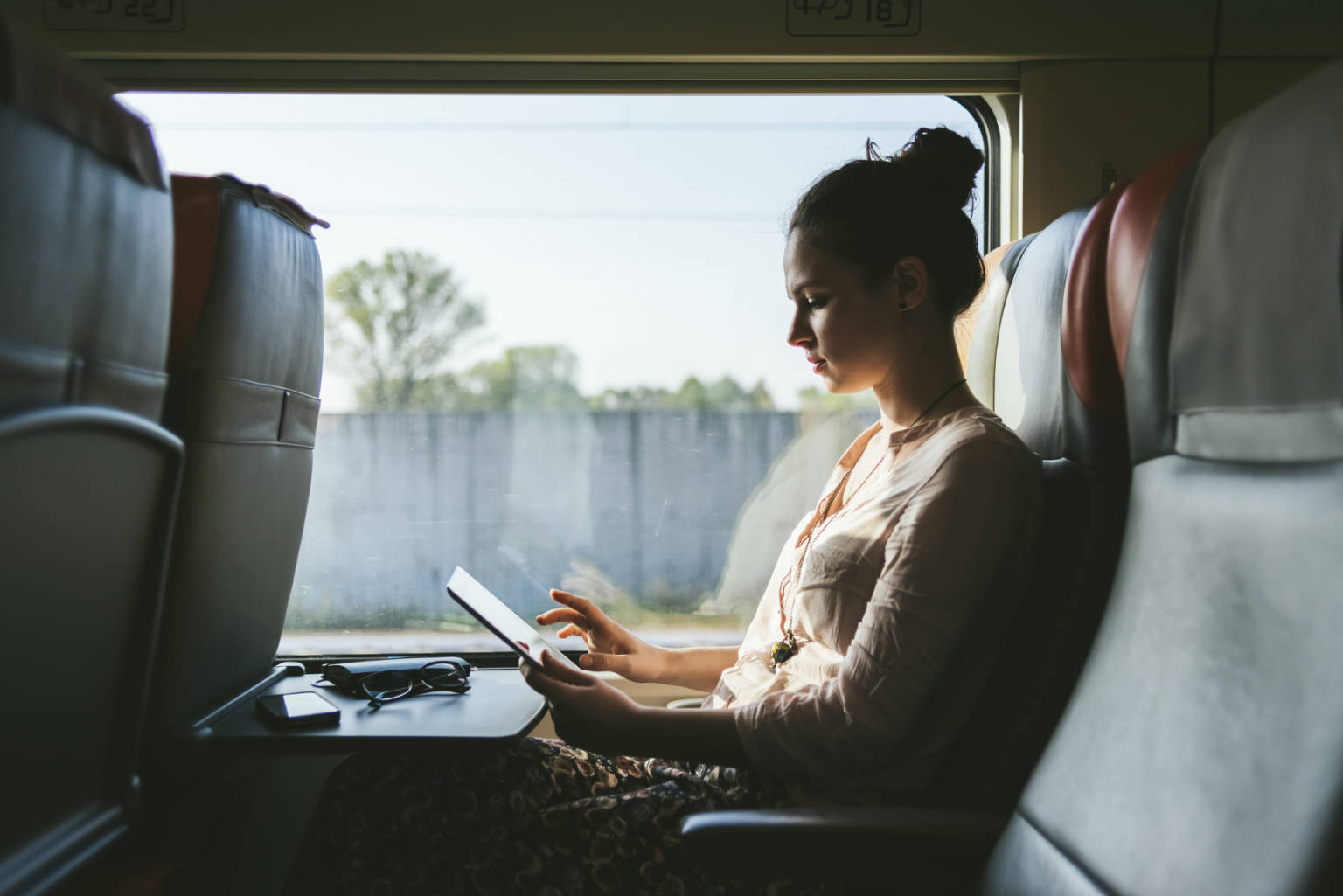Kvinna arbetar med mobilt bredband på tåg.