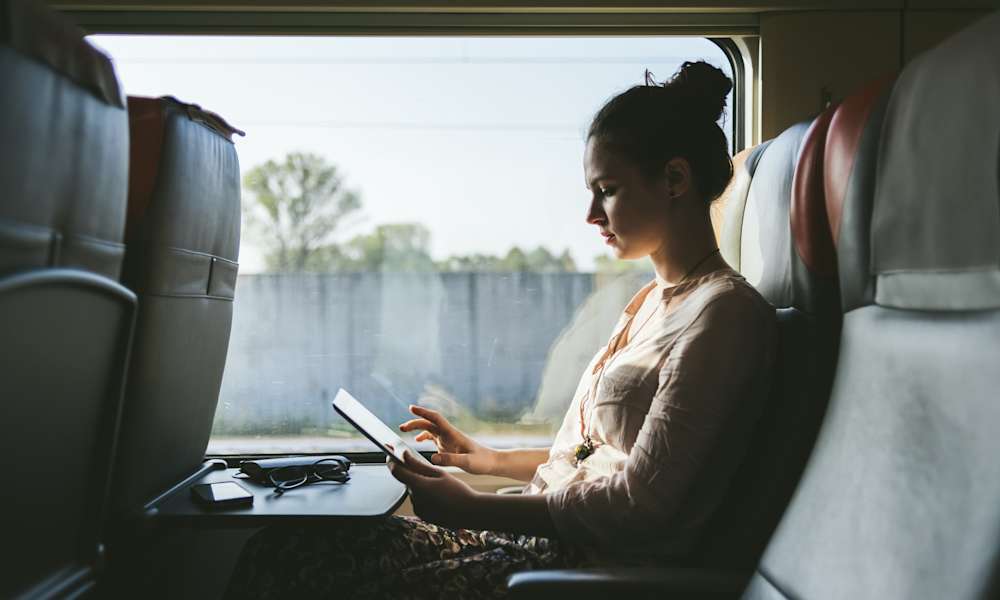 Kvinna arbetar med mobilt bredband på tåg.