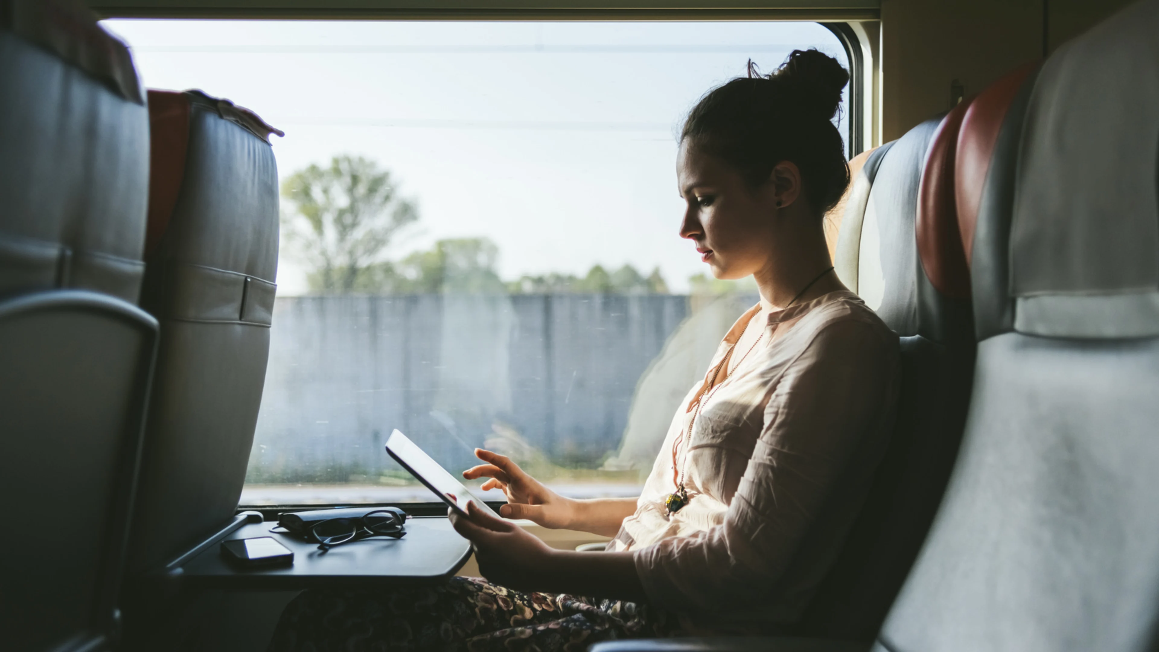 Kvinna arbetar med mobilt bredband på tåg.