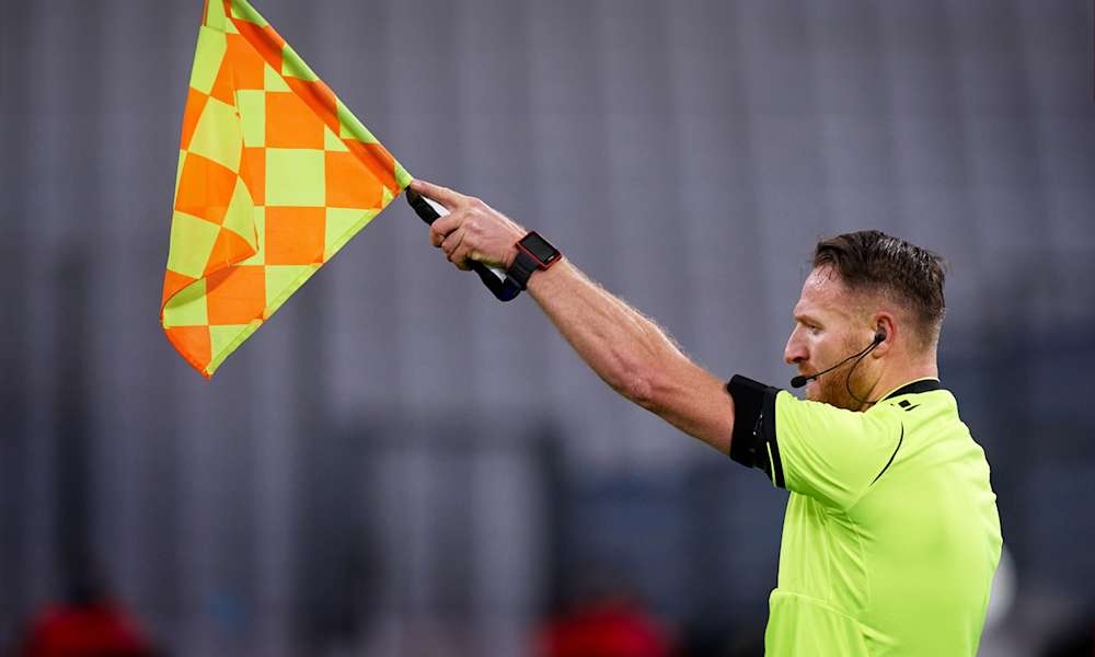 En domare vinkar offside under en match i UEFA Champions League.