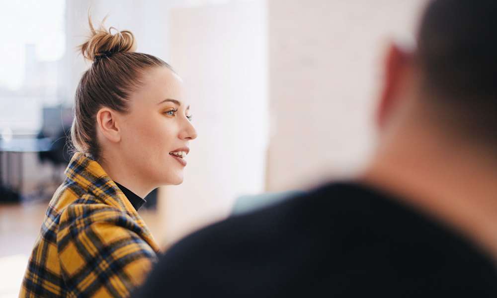 Kvinna och man vid bord med laptop