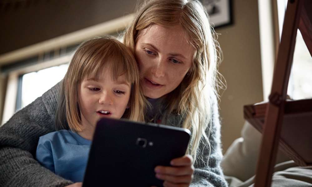 Kvinna och barn tittar på surfplatta