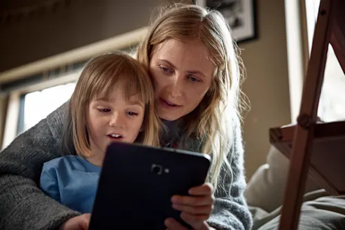 Kvinna och barn tittar på surfplatta