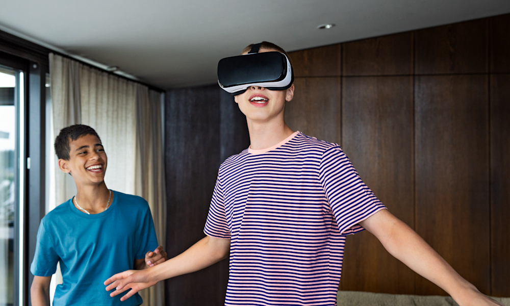 Två tonårskillar spelar spel med VR-headset.