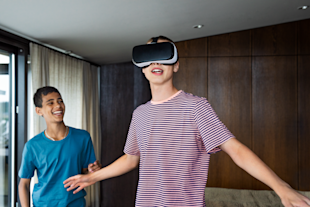 Två tonårskillar spelar spel med VR-headset.