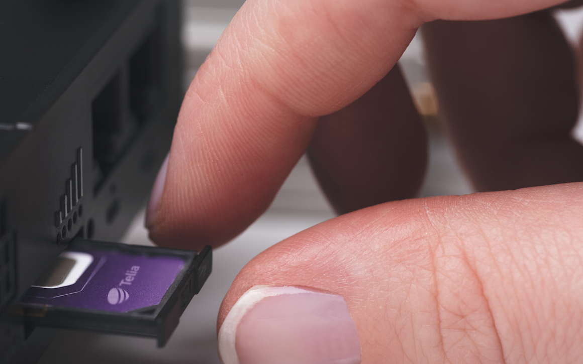 hand sätter in simkort i enhet