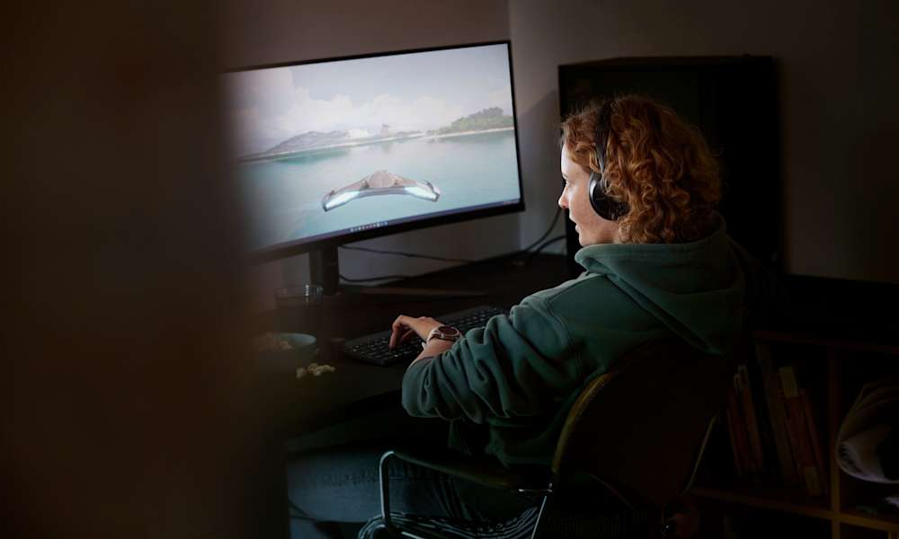 Kvinna spelar datorspel på en stor skärm.