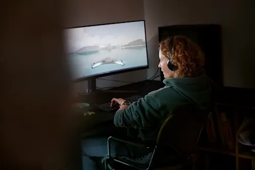 Kvinna spelar datorspel på en stor skärm.