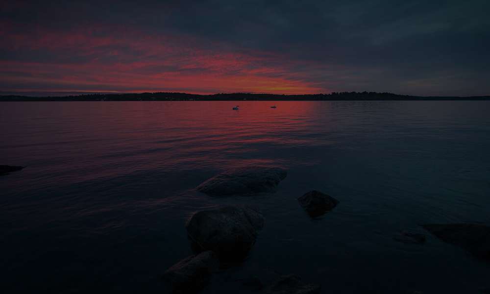 Utsikt över stilla sjö i skymningsljus.