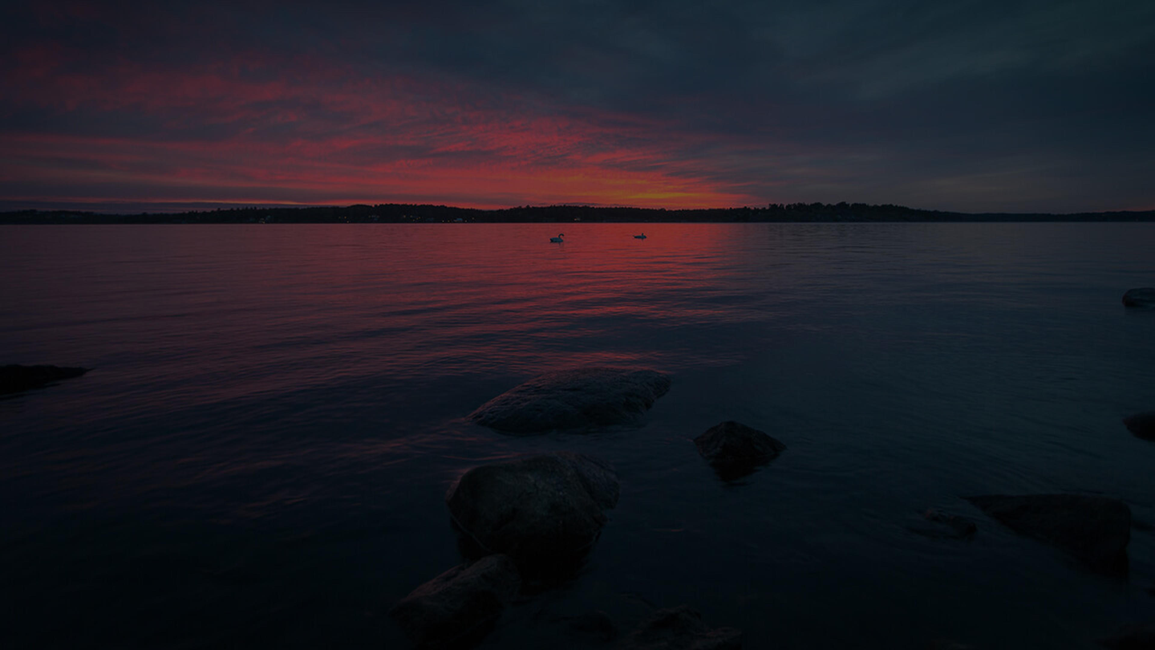 Utsikt över stilla sjö i skymningsljus.