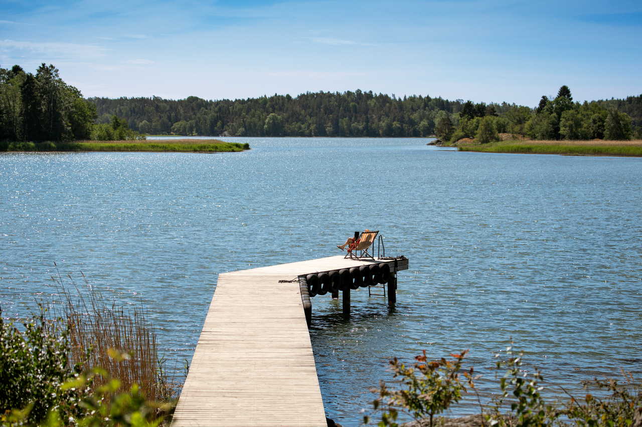 En kvinna med ryggsäck tar en bild med sin mobil.