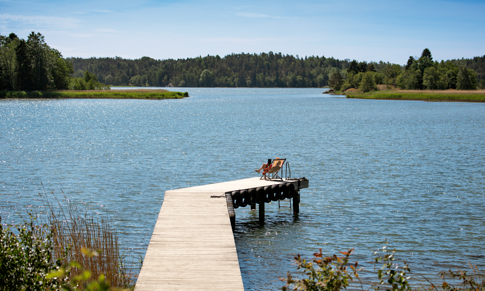 En kvinna med ryggsäck tar en bild med sin mobil.