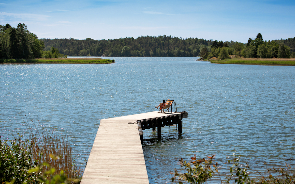 En kvinna med ryggsäck tar en bild med sin mobil.