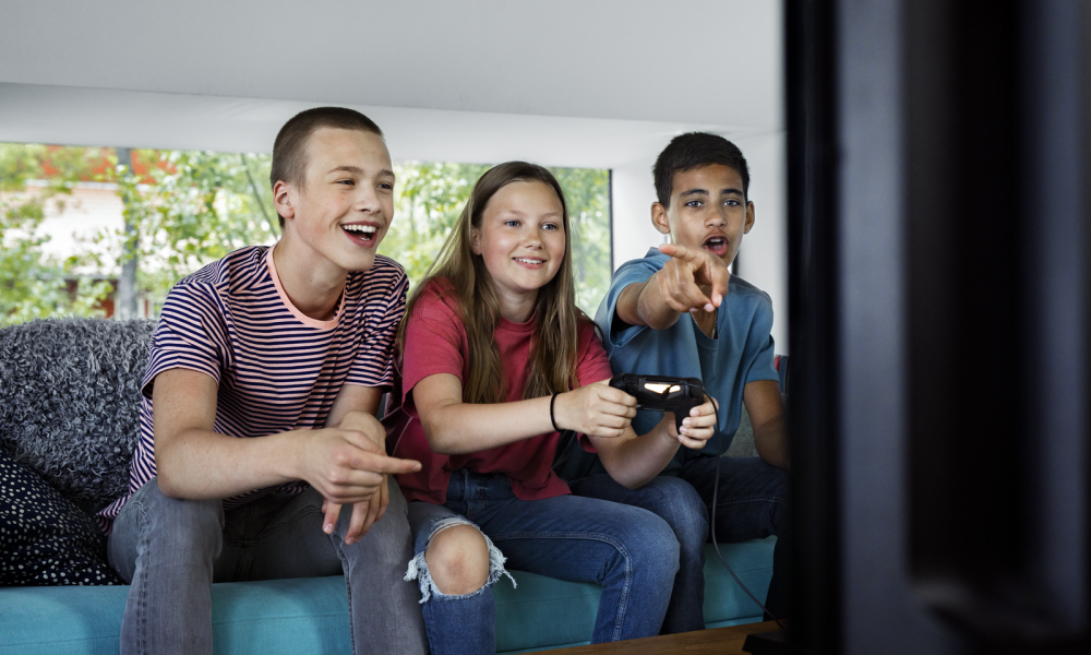 Tre ungdomar spelar tv-spel.