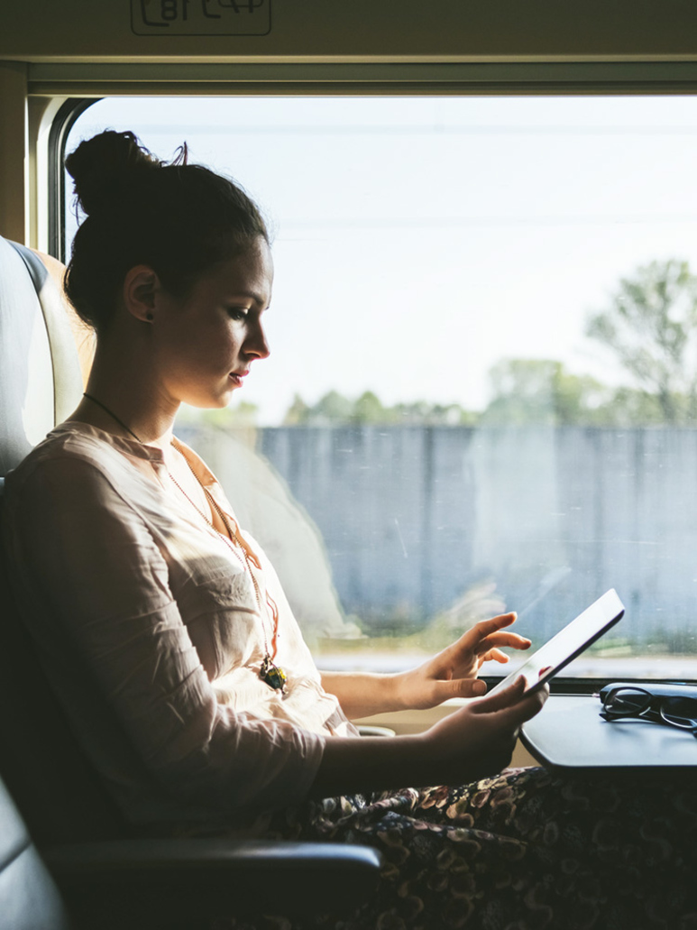 Kvinna arbetar med Microsoft 365-program i mobilen på tåg.