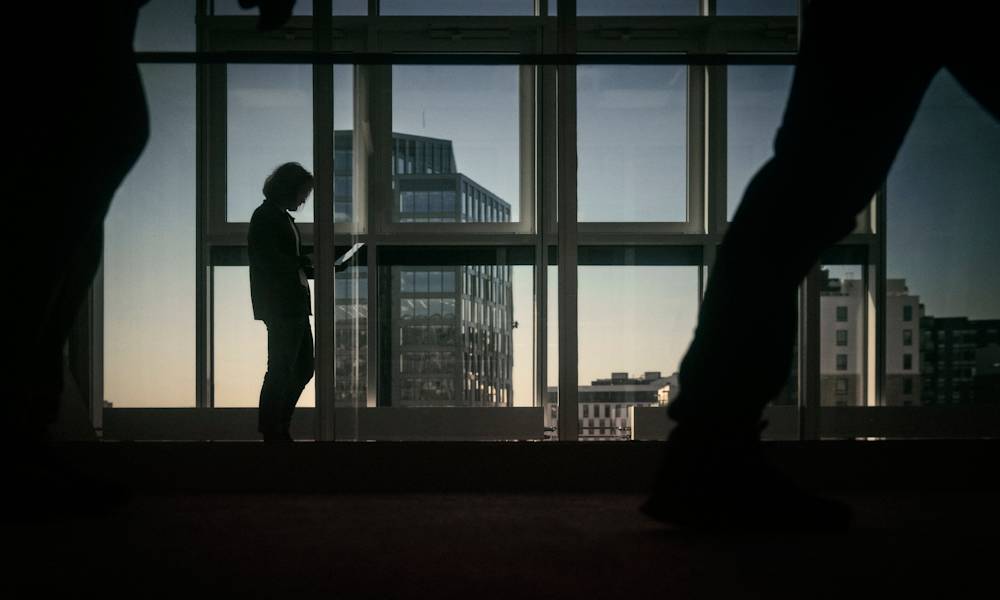 Man med dator i silhuett framför fönster