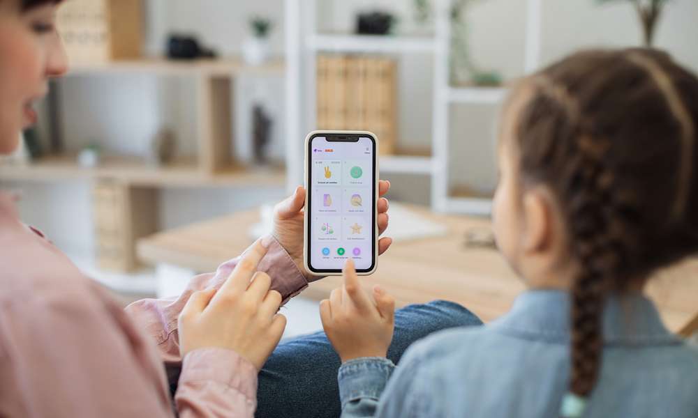 En flicka och hennes mamma gör Mobilkörkortet på mobilen.