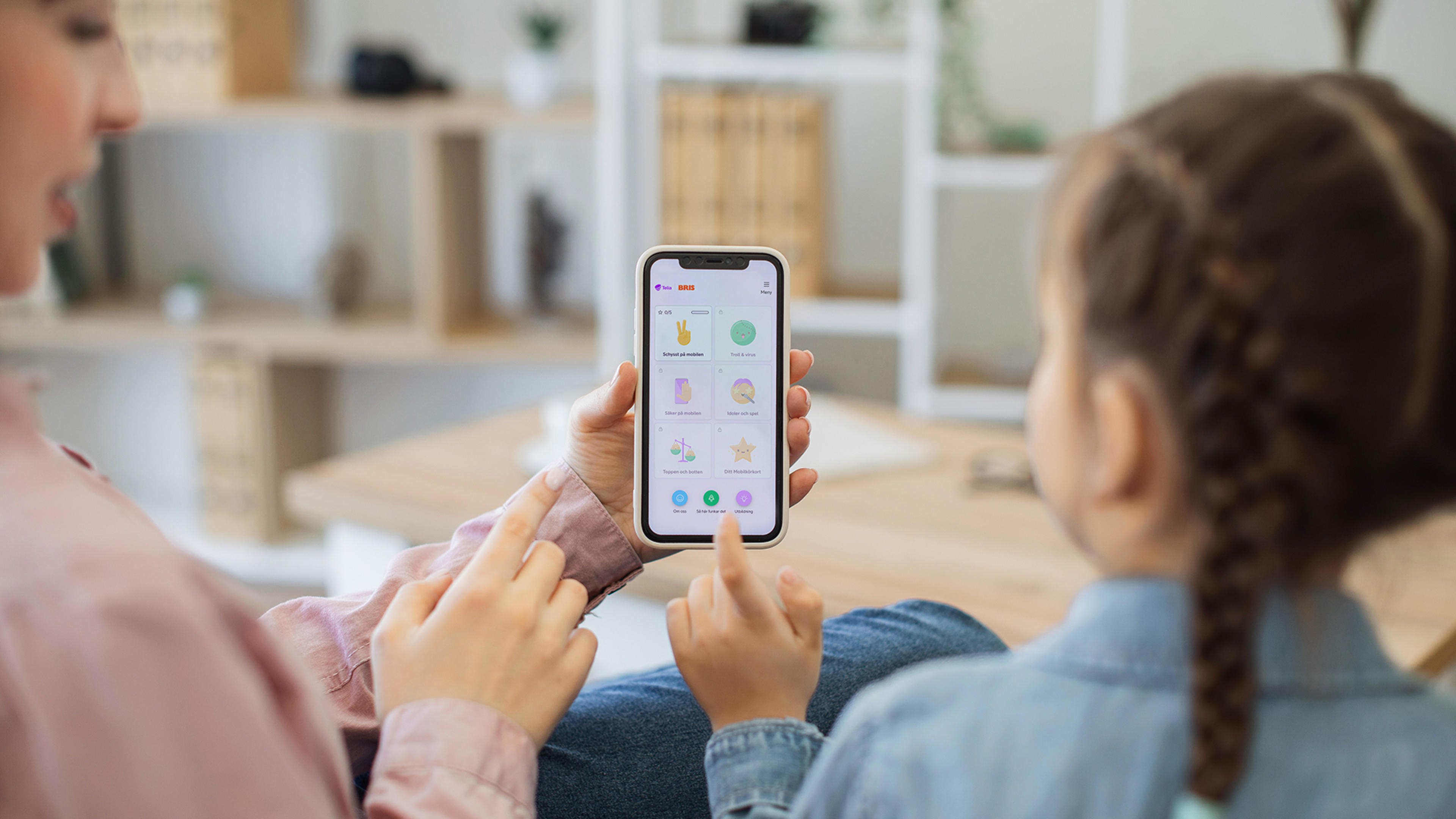 En flicka och hennes mamma gör Mobilkörkortet på mobilen.