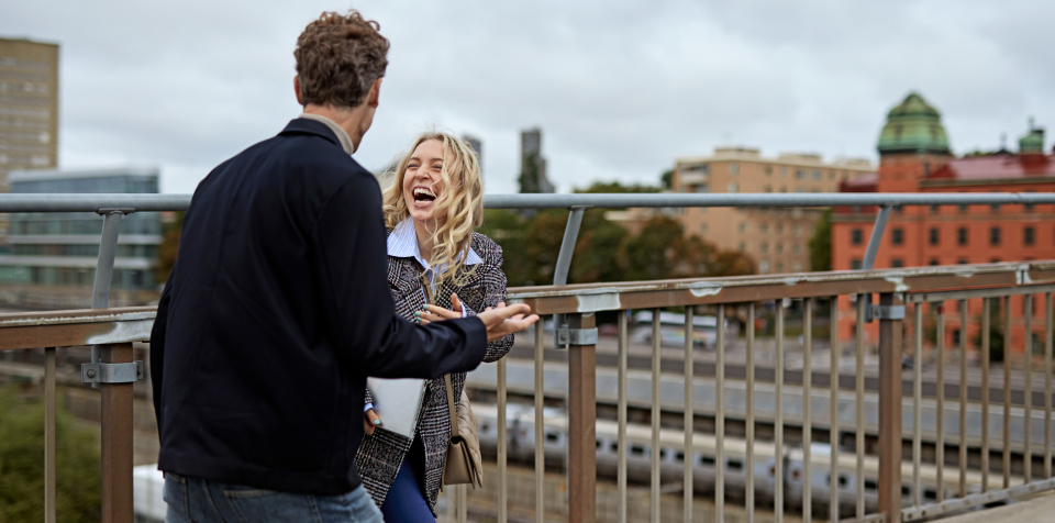 Kvinna och man pratar på takterrass i Stockholm