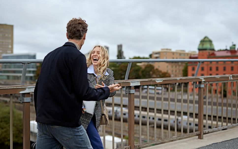 Kvinna och man pratar på takterrass i Stockholm.