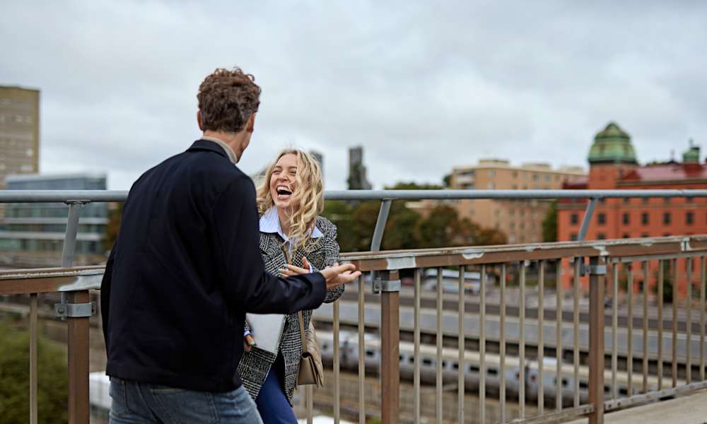 Kvinna och man pratar på takterrass i Stockholm