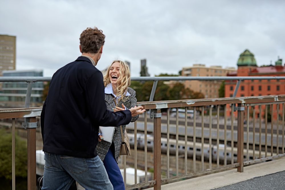 Kvinna och man pratar på takterrass i Stockholm